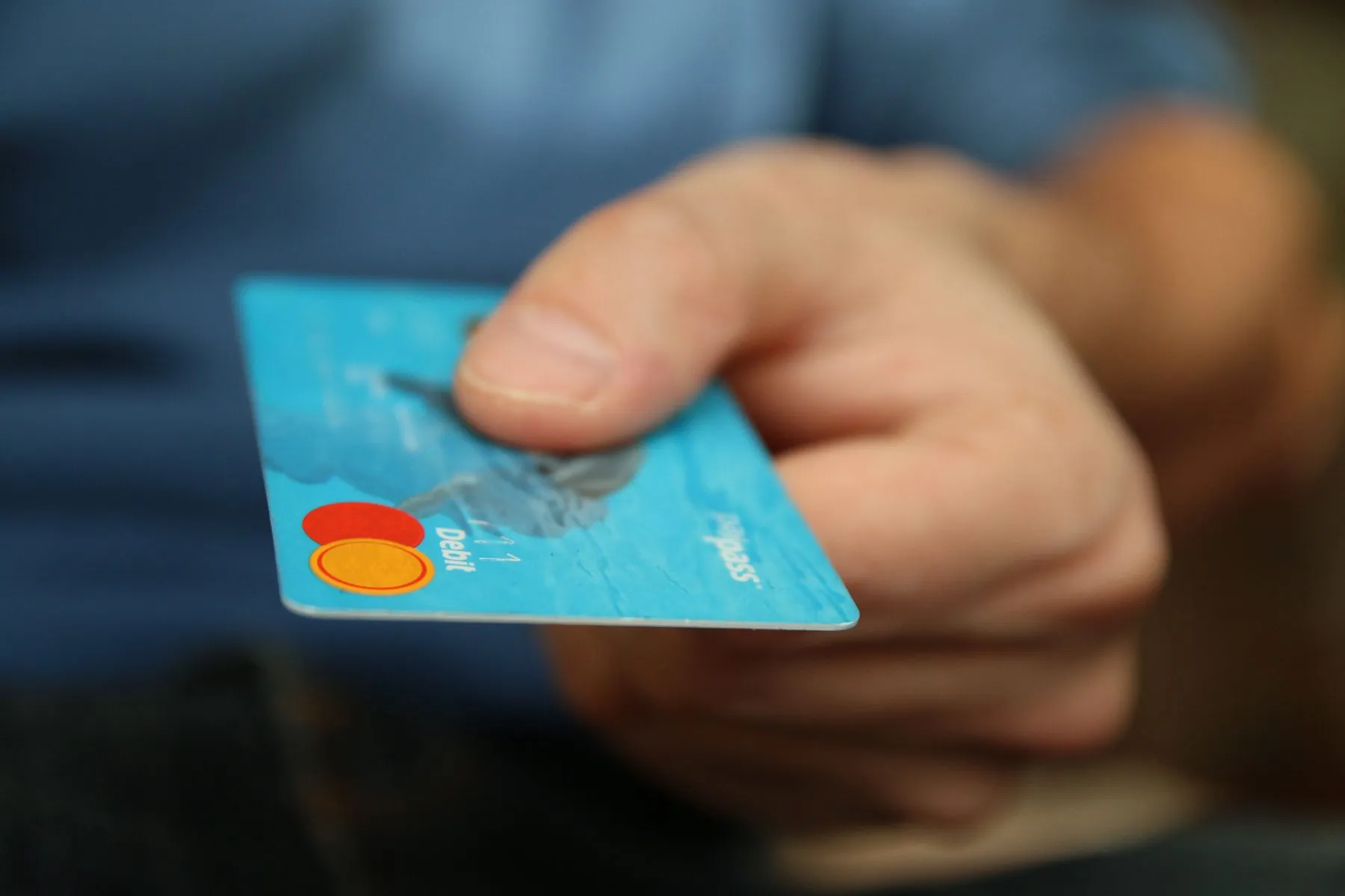 Hand holding a bank card, ready to pay for a car after converting crypto to lari