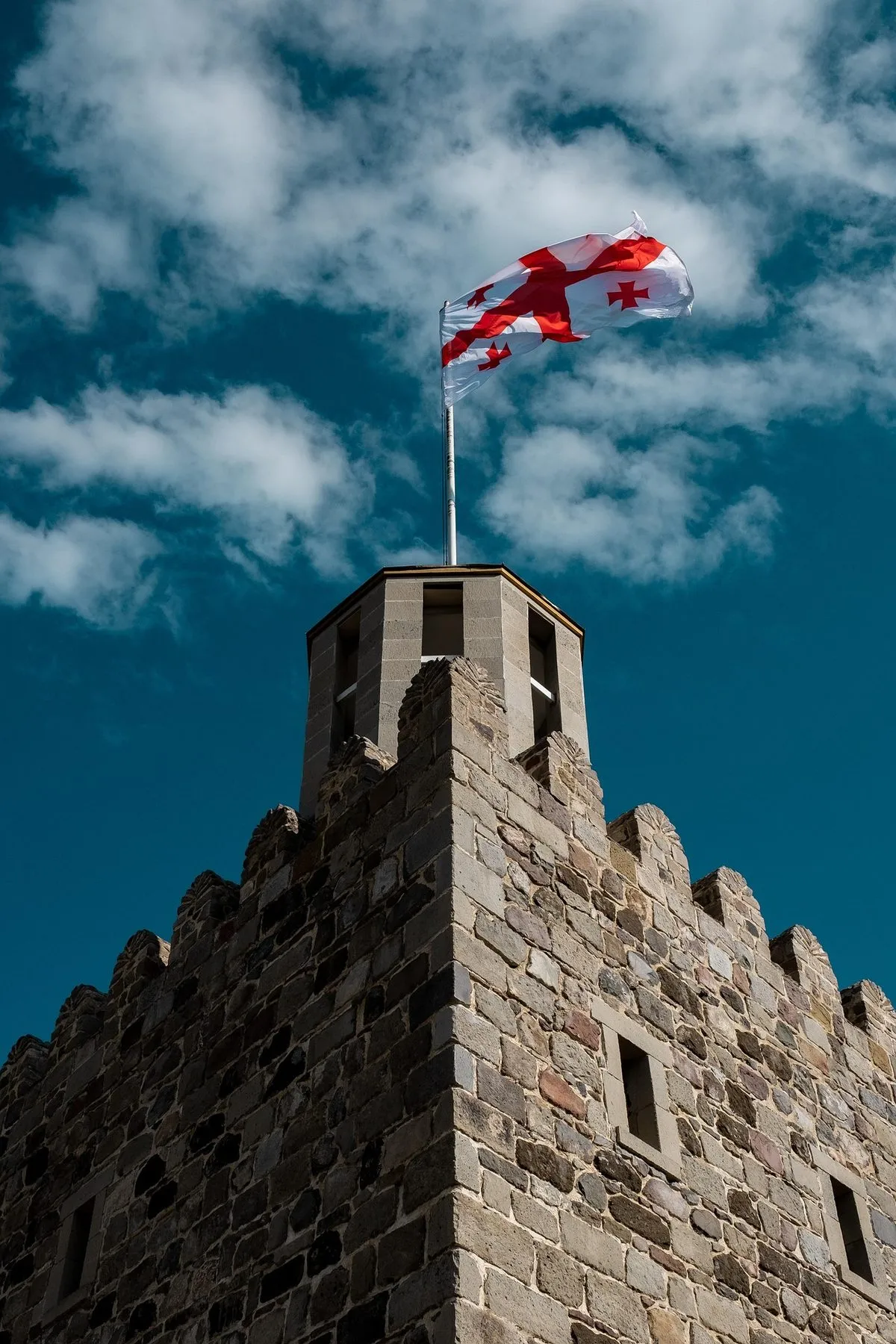 Georgian flag on top of a stone fortress tower