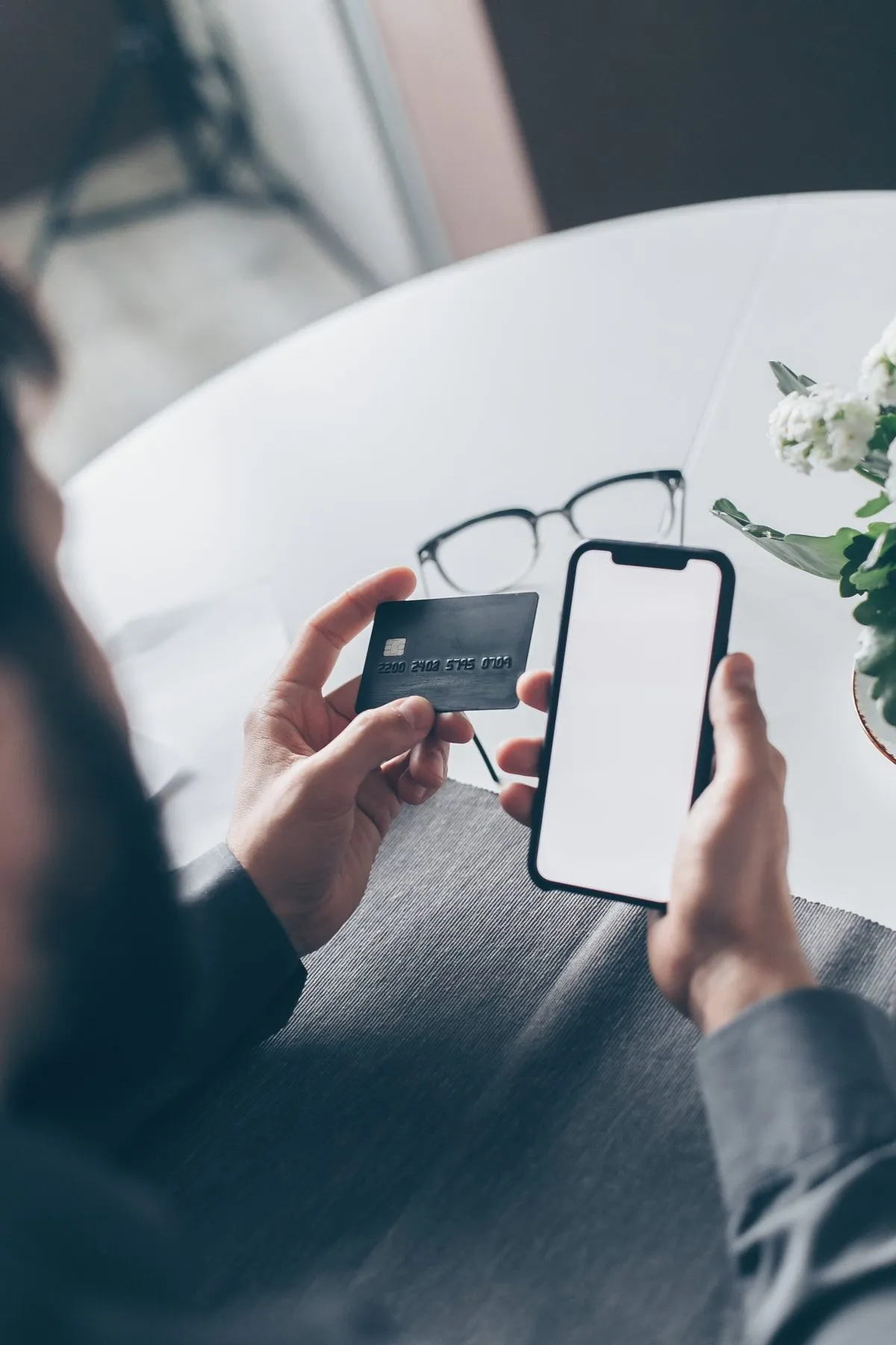 Man holding a bank card and smartphone, illustrating a KuCoin exchange review for users in Georgia