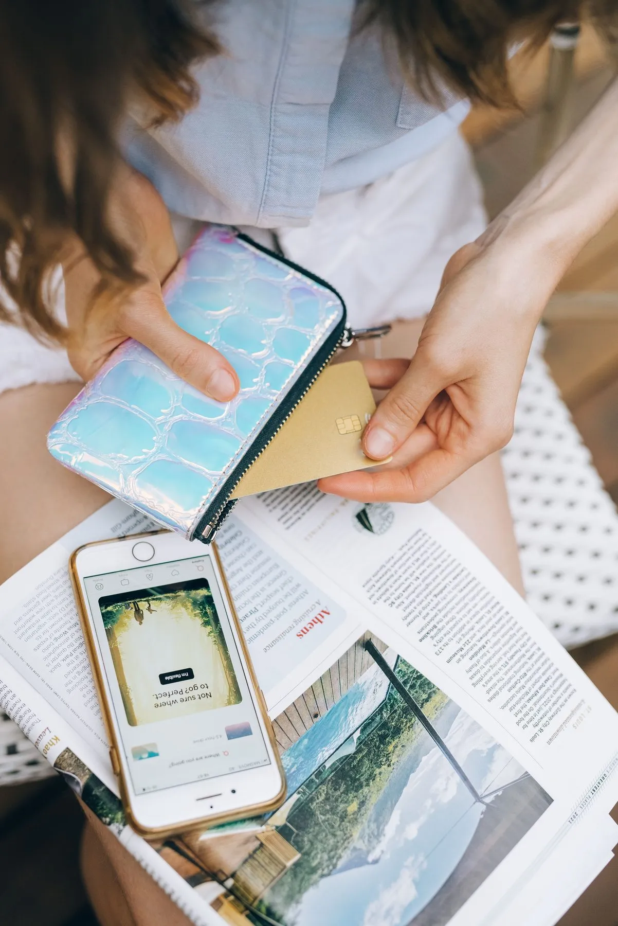 Using a mobile banking app with a bank card in hand