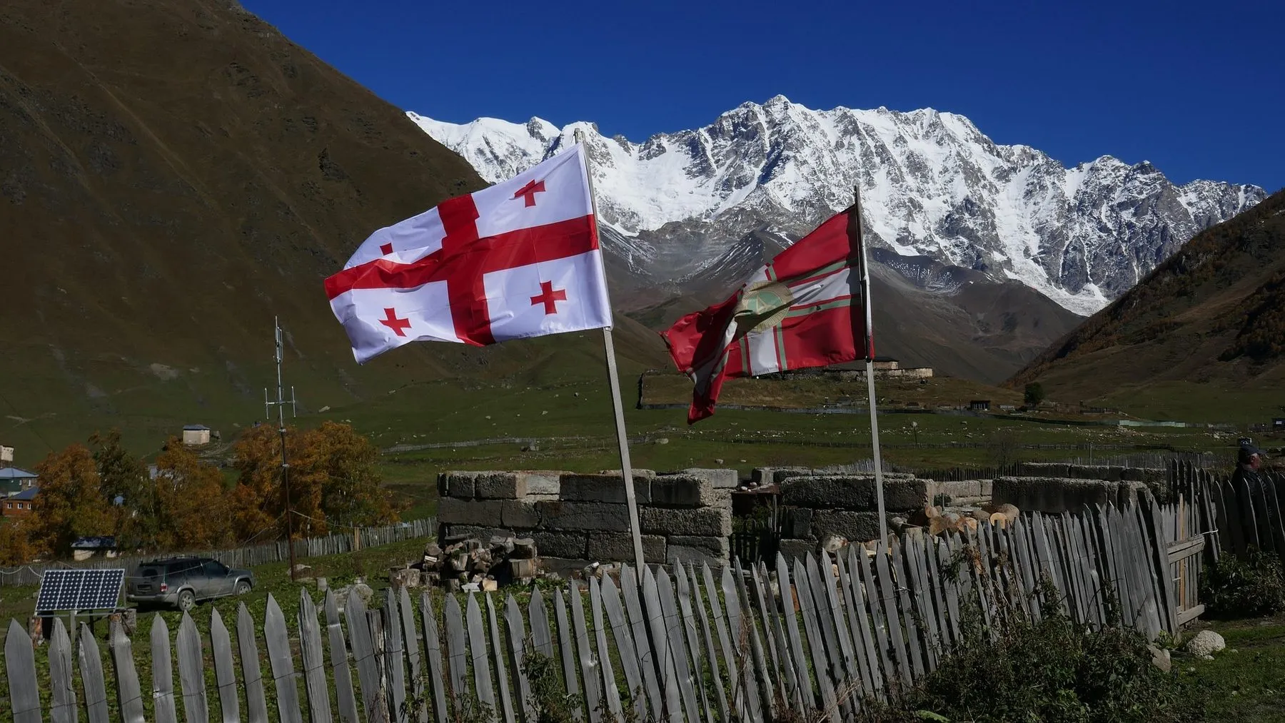 Georgian flags on a mountain ridge in Svaneti with the main Caucasus range behind
